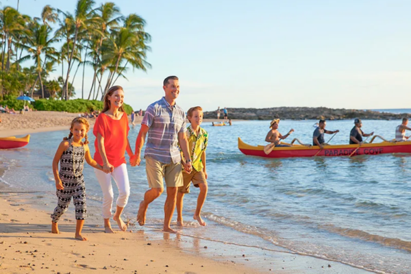 Family taking a leisurely stroll on Ko Olina shoreline