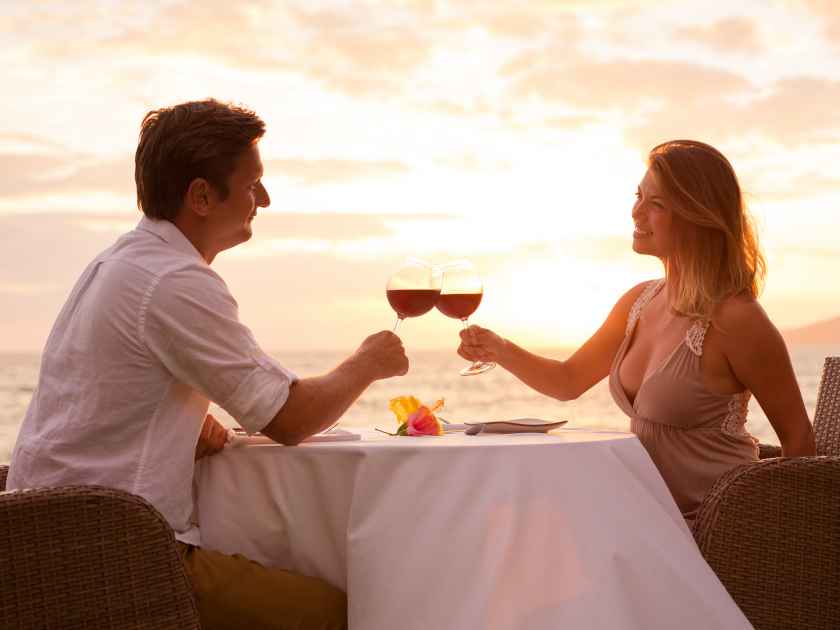 Couple sharing romantic sunset dinner on the beach