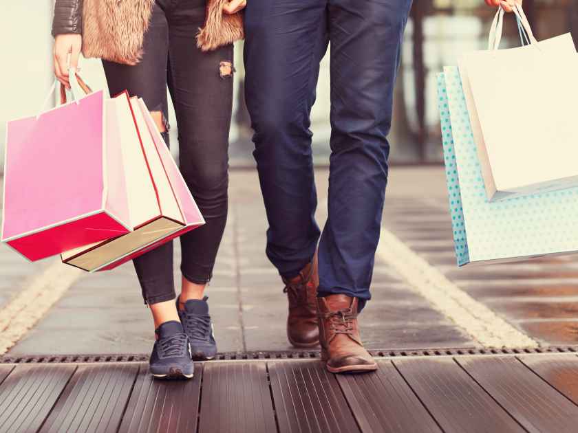 Midsection of couple with shopping bags in city