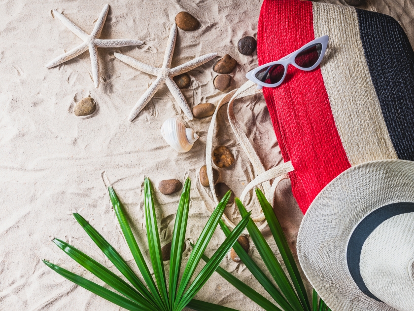 Top view traveler accessories on tropical white sand beach with palm leaves, Background for summer holiday vacation travel trip, Tourism summertime relaxing concept, Flat lay copy space for banner