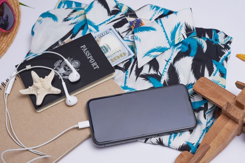 Flat lay travel accessories on white background palm leaf, camera, hat, passports, money, hawaii, book, phone, and sunglasses. Top view, travel or vacation concept. Summer background.