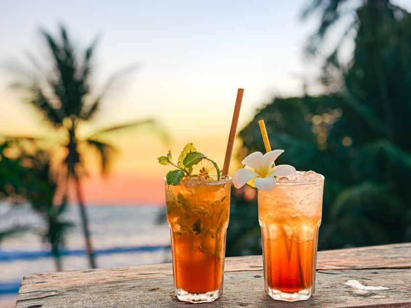 drinks with blur beach and sunset in background