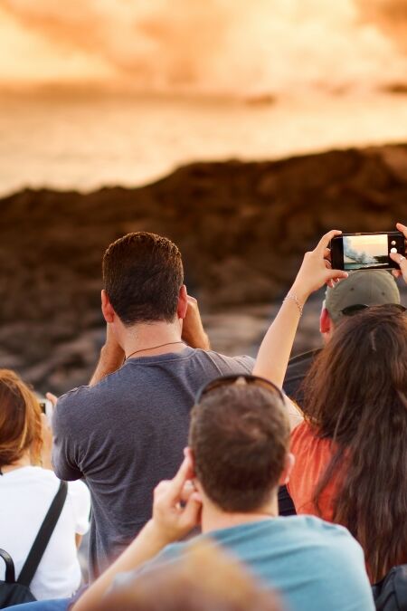 Tourists taking photos at Kalapana lava viewing area. Lava pouring into the ocean creating a huge poisonous plume of smoke at Hawaii's Kilauea Volcano, Volcanoes National Park, Big Island of Hawaii