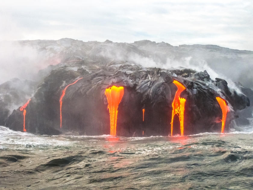 Close up of Kilauea Volcano, Hawaii Volcanoes National Park, also known Kilauea Smile because from 2016 seems to smile, erupting lava into Pacific Ocean, Big Island. Scenic sea view from the boat.