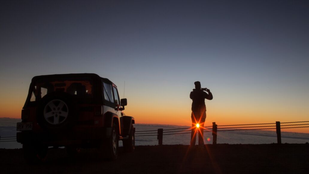 Tourist photographing sunrise at summit of Mauna Kea - Hawaii