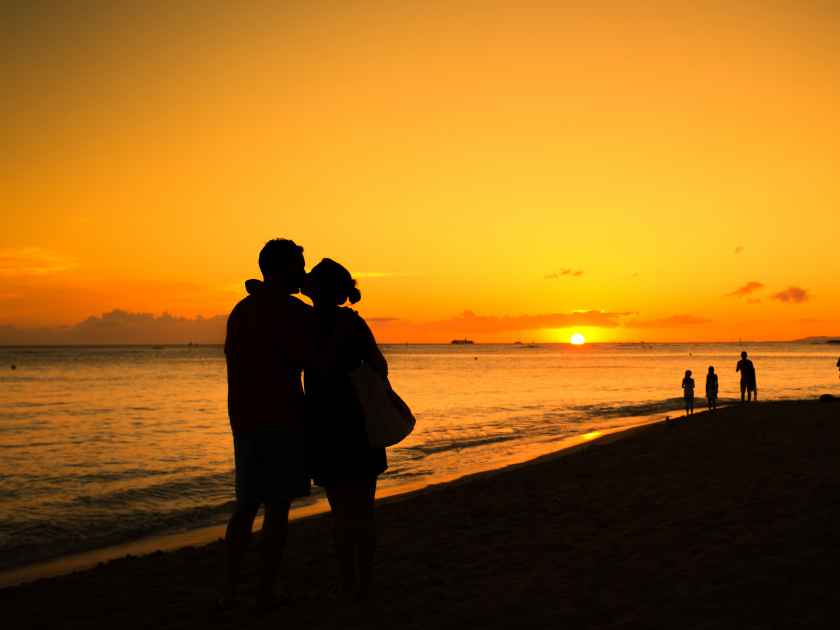 Silhouette of couple in love kissing at sunset