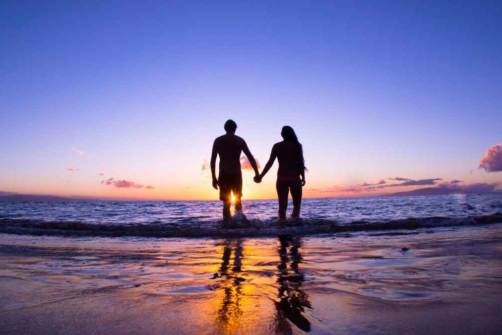 Romantic couple enjoying a beach walk at sunset