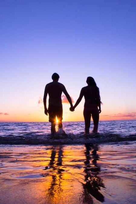 Romantic couple enjoying a beach walk at sunset