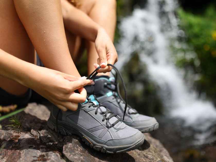 Close up portrait of a hiker tying shoe laces in the mountain