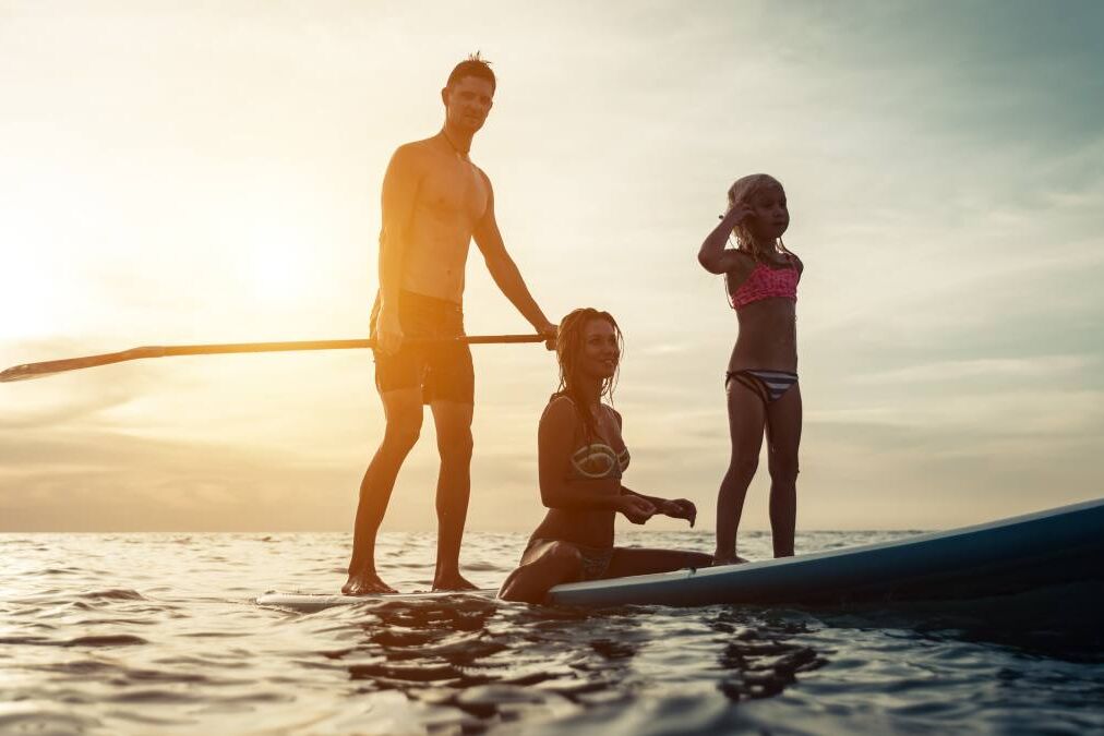 surfing. happy family silhouette on the paddle board. concept about family, sport and fun