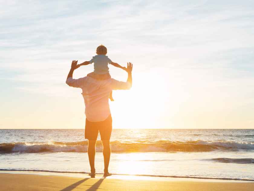 Happy Father and Son Having Fun Playing on the Beach at Sunset. Fatherhood Family Concept