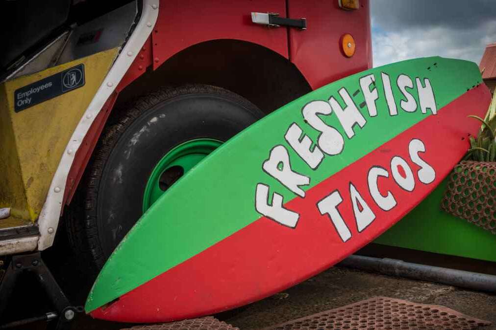 Food truck using a surfboard as a sign for fresh fish tacos