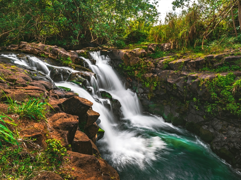A side view of Hoʻopiʻi Falls, a series of waterfalls along the Kapaʻa Stream, located near Kapaʻa town on the island of Kauai, Hawaii, United States.