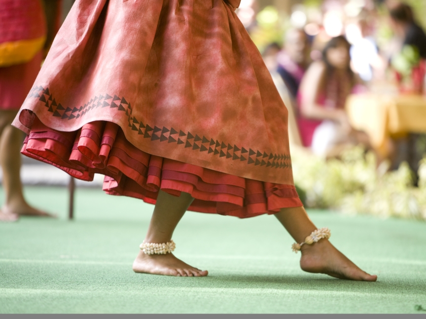 Close up of a hula dancer on a stage, focus on the her feet.