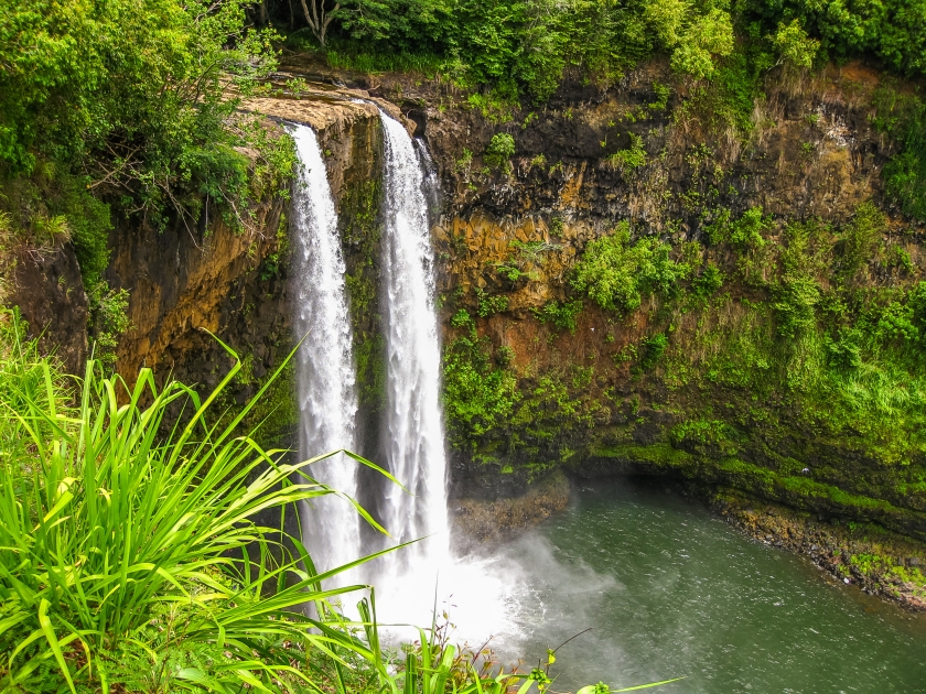 Aerial view of tropical Manawaiopuna Falls also called Jurassic Park Falls in Kauai, Hawaii, USA. .