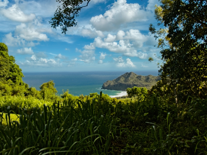 Beautiful view of a coastline with majestic clouds mountains view with beautiful green tropical gardens, overlook of Kipu Kai Beach in Kauai, Hawaii, USA