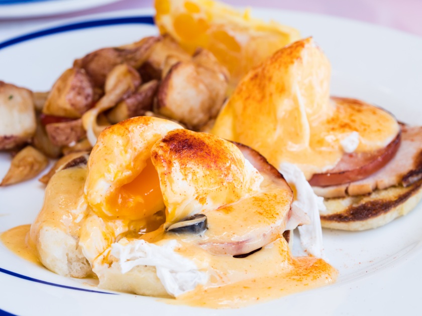 Famous Breakfast in Hawaii, Eggs Benedict toasted English muffins, ham, poached eggs, and delicious buttery hollandaise sauce in Waikiki, Hawaii.