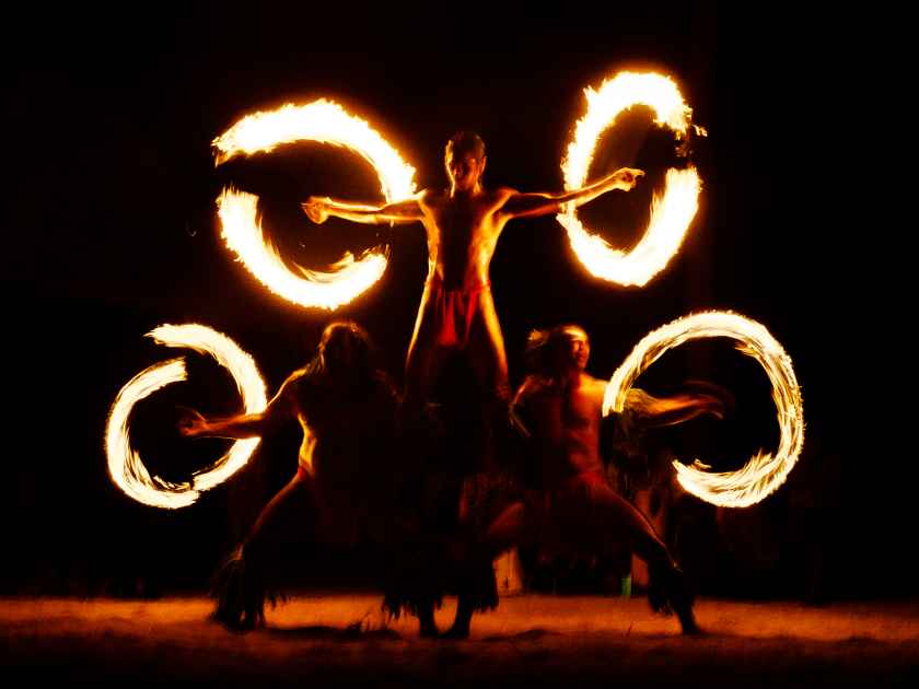 Luau Hawaii, French Polynesia fire dance silhouettes of professional dancers at night on beach resort tiki party.