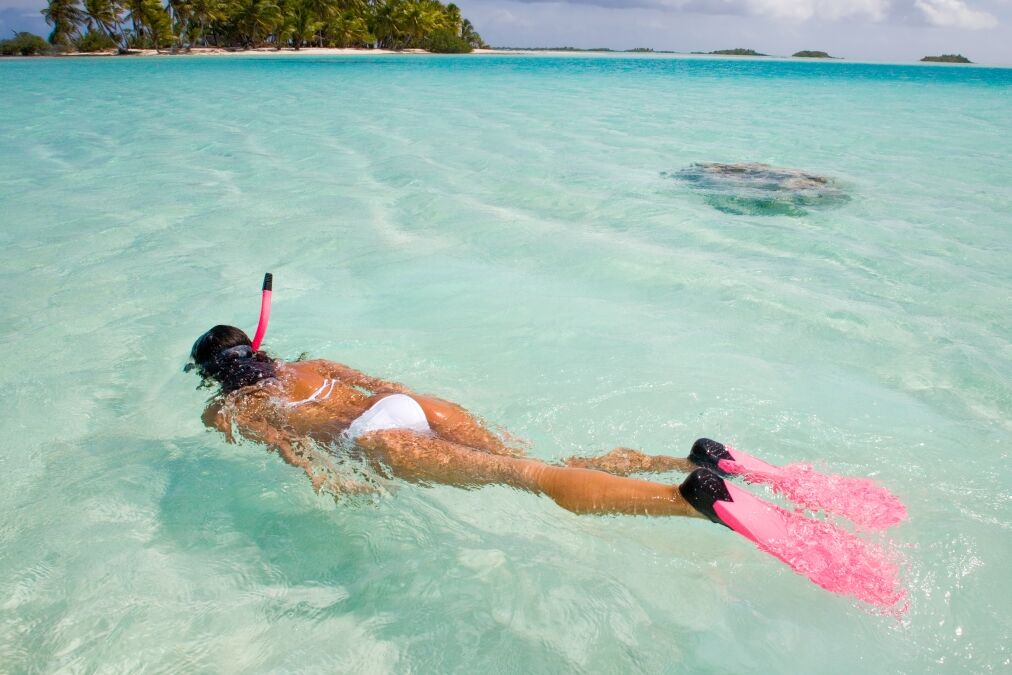 active woman free diving snorkeling in beautiful blue ocean on summer vacation