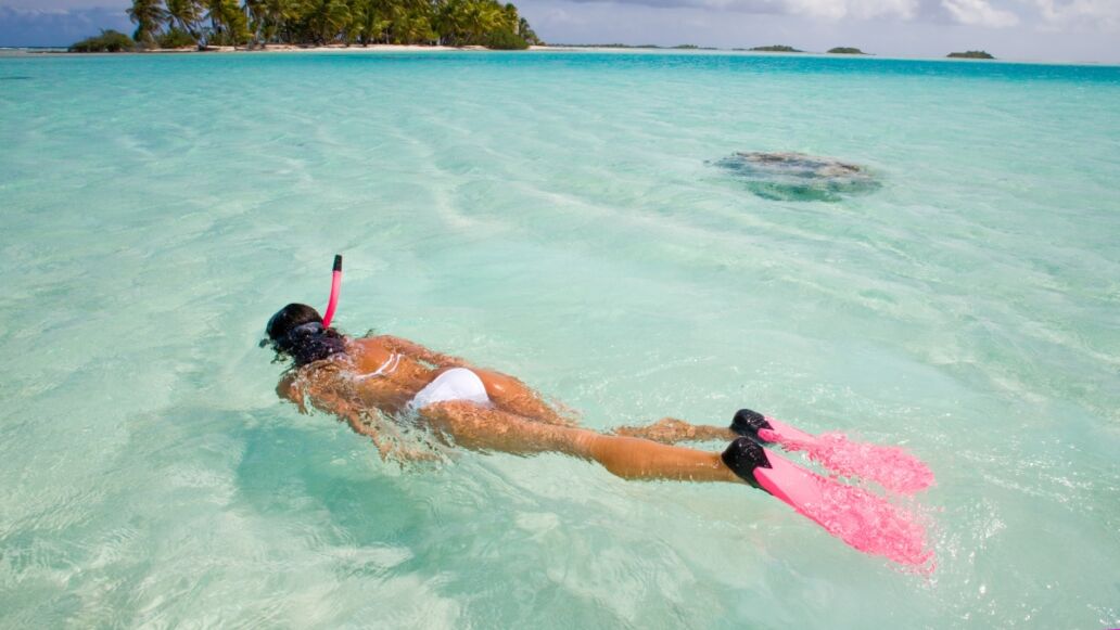 active woman free diving snorkeling in beautiful blue ocean on summer vacation