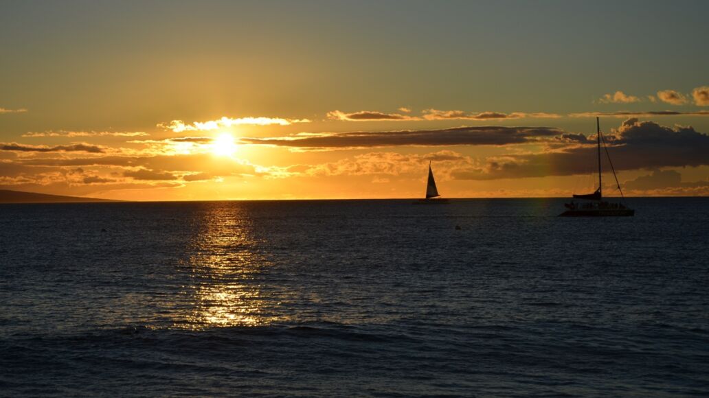 A,Breathtaking,Hawaiian,Sunset,Illuminates,The,Sky,,As,Boats,Glide