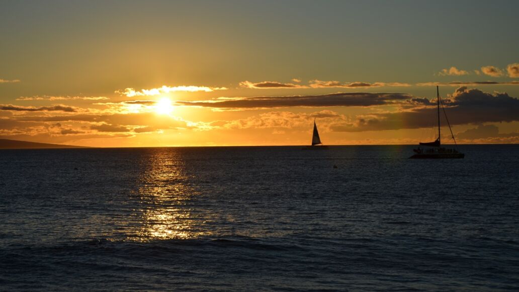A,Breathtaking,Hawaiian,Sunset,Illuminates,The,Sky,,As,Boats,Glide