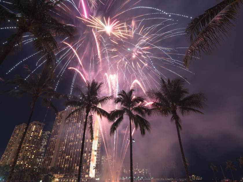New Year’s 2018 fireworks at the Hilton Hawaiian Village in Honolulu, Hawaii with the beach, palm trees and a lagoon