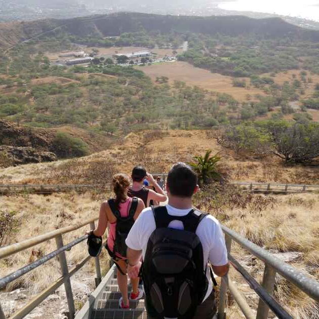 Hikers climbing down stairs leaving the lookout at Diamond Head Crater lookout on Oahu, Hawaii.