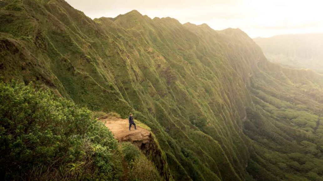 Solo woman model hiking at the summit of the Koolau mountain range on Oahu, Hawaii