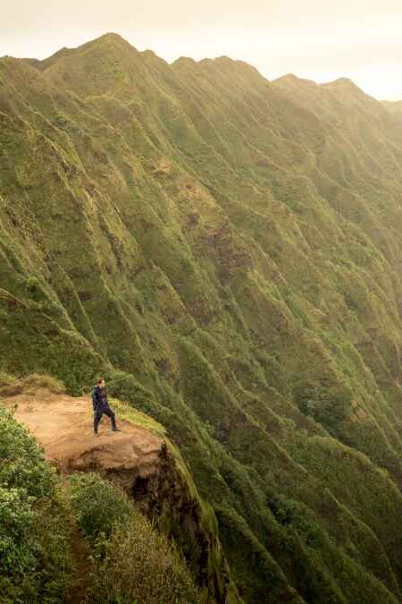Solo woman model hiking at the summit of the Koolau mountain range on Oahu, Hawaii
