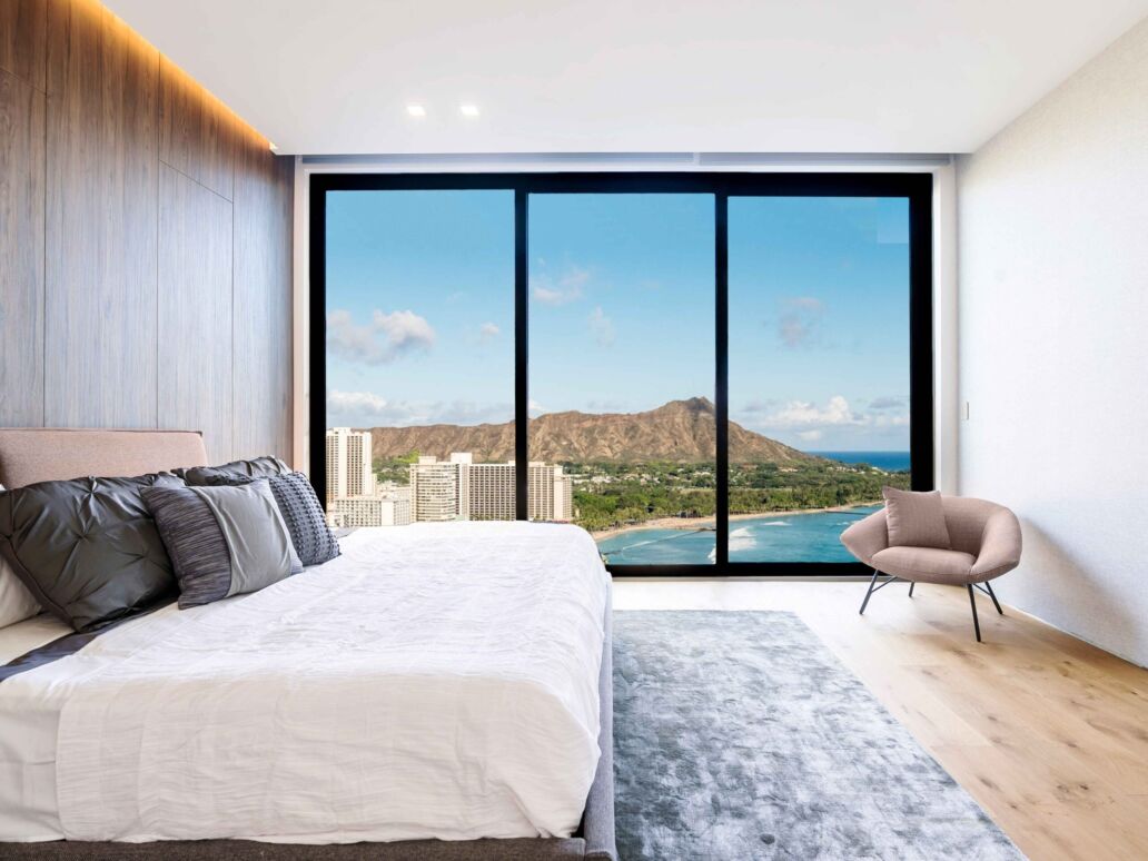 Modern and luxurious hotel bedroom with views of Waikiki beach and skyline in Honolulu, Hawaii. Condo or 5-star upscale accommodation.