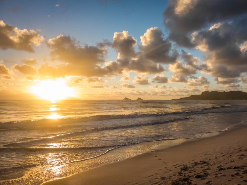 A gorgeous golden sunrise turns into blue skies over Kailua Bay on the island of Oahu, Hawaii.