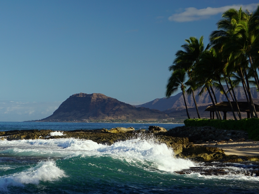 View of a beach in Ko Olina Lagoons along Oahu's west shore, with the Waianae Mountains in the distance.
