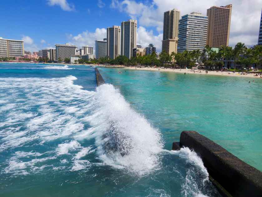 Wave Crashing on Breakwater Wall at Kuhio Beach Lagoon - View of Lagoon, Beach and Hotel Skyline - Waikiki Beach, Honolulu, Oahu, Hawaii