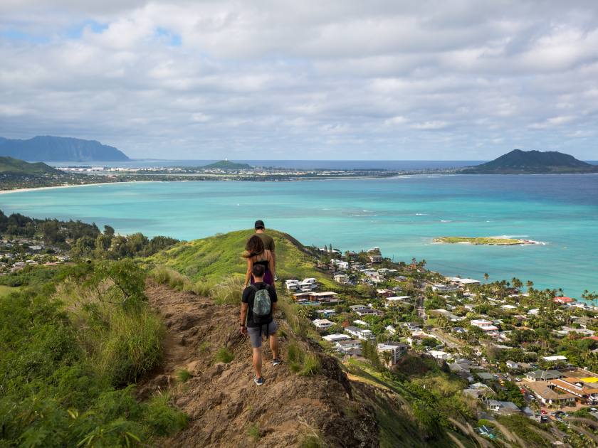 Hikers with the view of Lanikai from a top the Pillbox hiking trail Kailua Hawaii in December