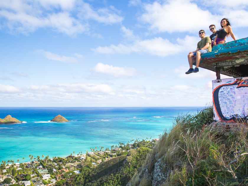 A group of friends sitting on pillbox over looking Lanikai in Kailua Hawaii