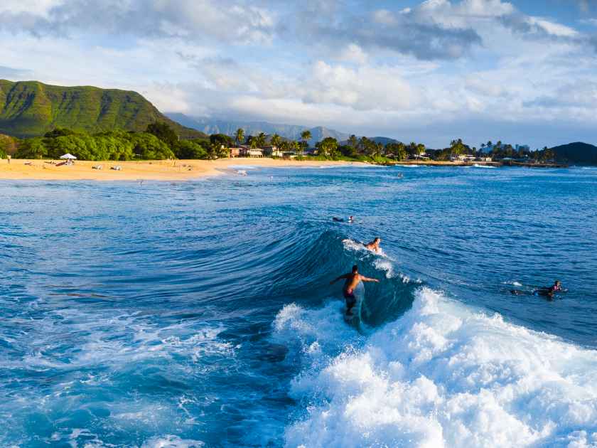 Panorama of the surf spot Makaha with the surfer riding the wave. Oahu, Hawaii