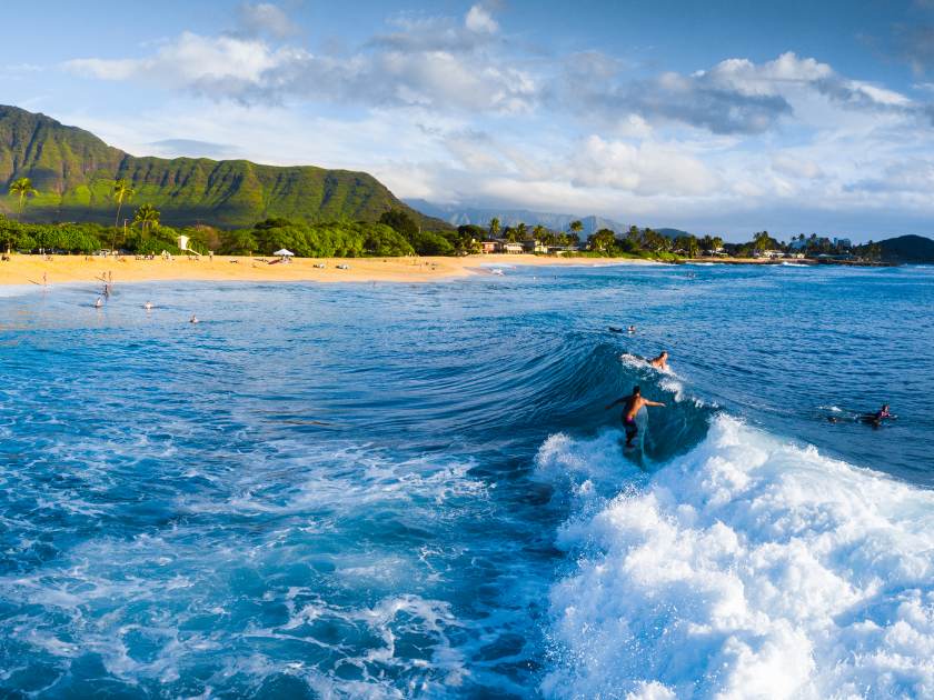 Panorama of the surf spot Makaha with the surfer riding the wave. Oahu, Hawaii