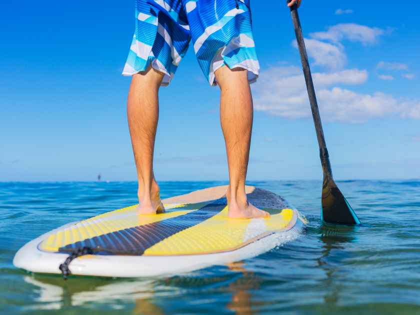 Young Attractive Mann on Stand Up Paddle Board, SUP, in the Blue Waters off Hawaii