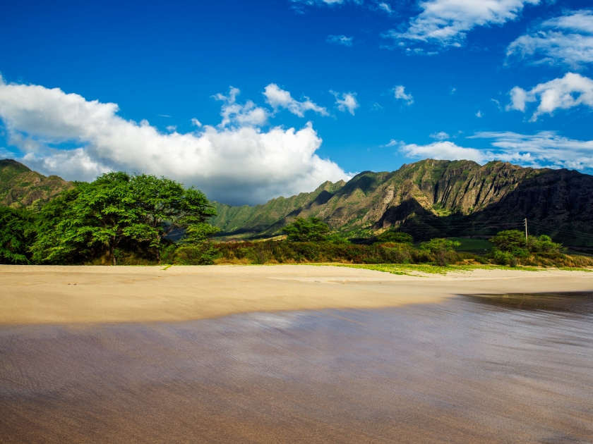 Makua beach view with beatiful mountains and cloudy sky in the background, Oahu island, Hawaii