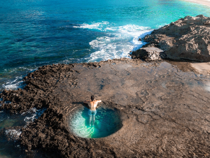 Makua beach Oahu, Hawaii. Girl man in tide pool - natural pool. Enjoy view to the mountain.Makua beach Oahu, Hawaii. Girl man in tide pool - natural pool. Enjoy view to the mountain.