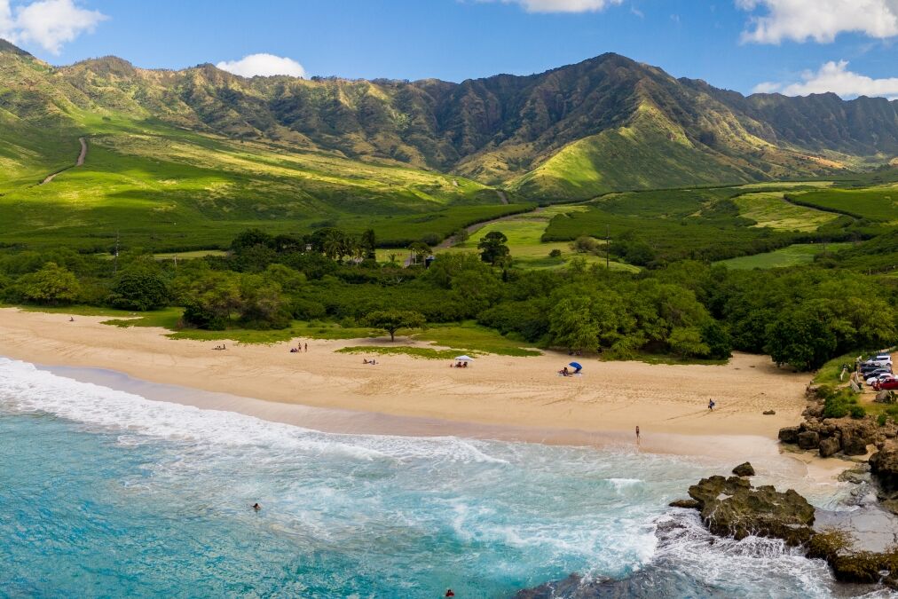 Broad panorama of Makua beach and valley from aerial view over the ocean on west coast of Oahu, Hawaii