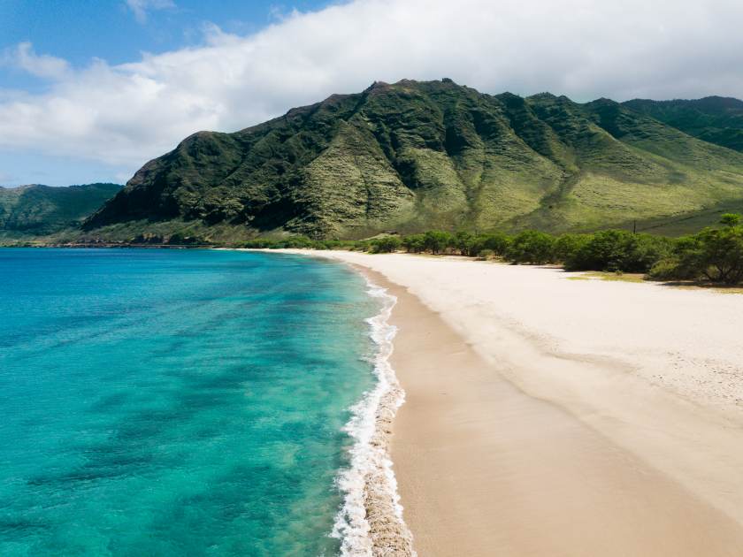 Tropical paradise beach with white sand and mountain background travel tourism wide panorama background. Hawaiian beach. West Oahu. Makua beach.