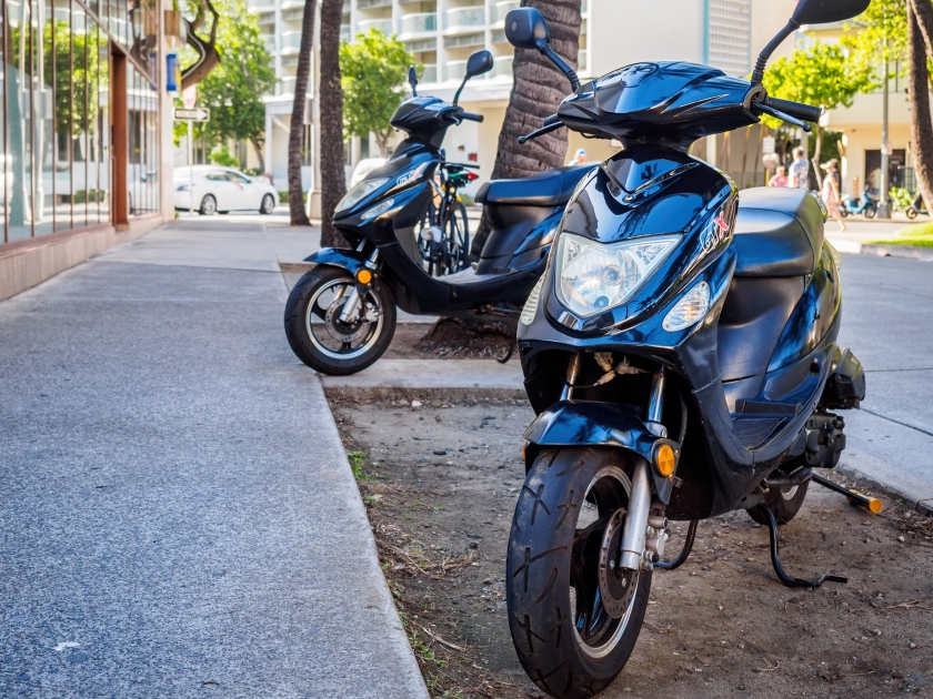 Waikiki Area, Honolulu, Hawaii, USA - December 11, 2015: Two black motobikes seen parked on footpath along Kaiulani Avenue. Perfect mode of transport around the Waikiki area.