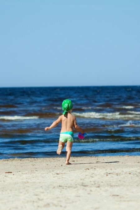 Family of two frolicking on the beach.Some parts in motion (they were running).