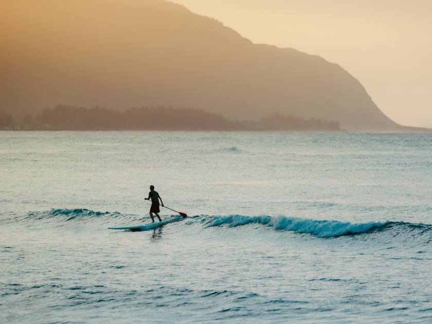 Paddleboard surfer silhouette on Hawaii Beach. Outdoor sports lifestyle.