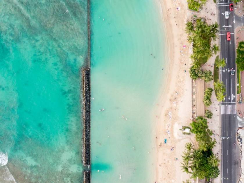 Stunning aerial drone view of Kuhio Beach, part of Waikiki Beach in Honolulu on the island of Oahu, Hawaii. The beach is protected from the ocean through a concrete wall, making it an ocean pool.