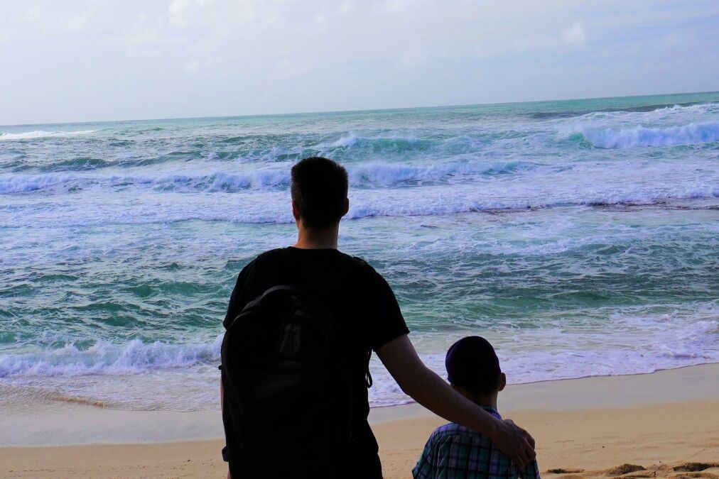 Father and son at Sunset Beach, a picturesque beach in North Shore, Oahu.