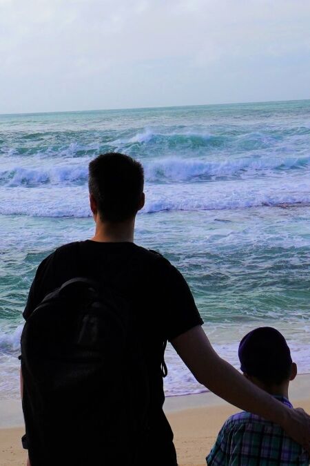 Father and son at Sunset Beach, a picturesque beach in North Shore, Oahu.