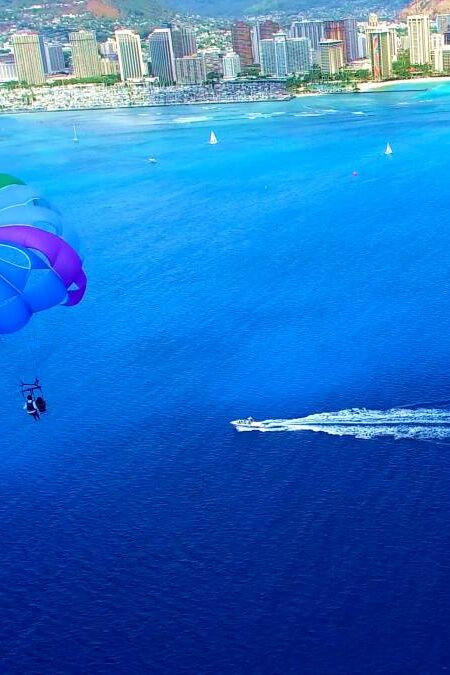 Parasailer With Rainbow Parachute Off The Coast of Honolulu/Waikiki Beach - Aerial Footage in Oahu, Hawaii